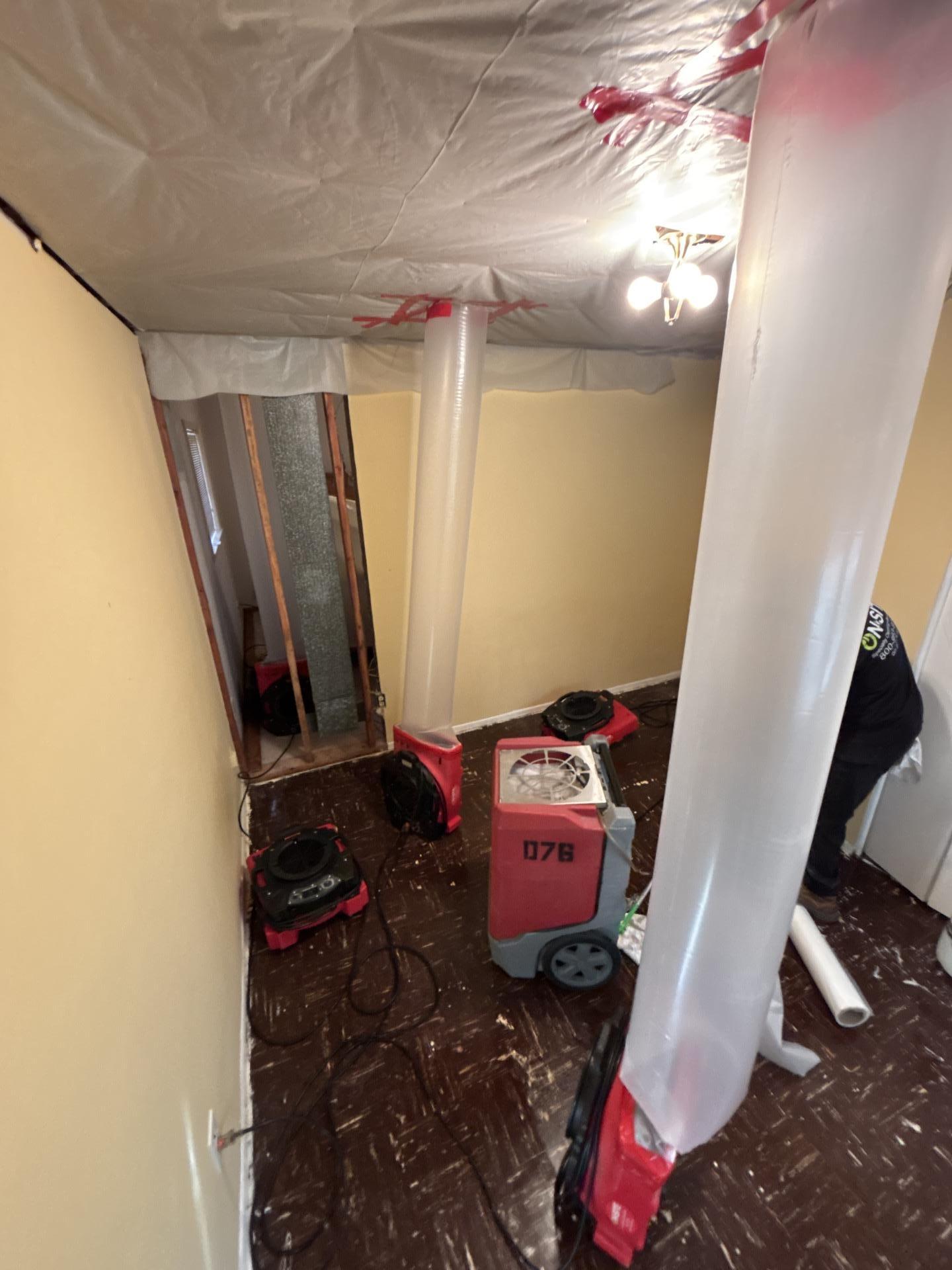 Does homeowners insurance cover a burst pipe or an appliance leak? | On-Site Specialty Cleaning + Restoration Bedroom in Dearborn Heights with the opened ceiling tented in plastic, air movers ducted into the ceiling cavity and a dehumidifier running